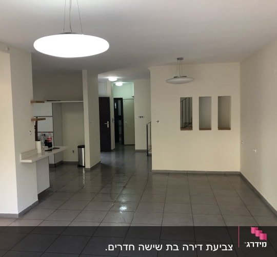 חדר ריק עם קירות צבועים בלבן ותאורה עליונה